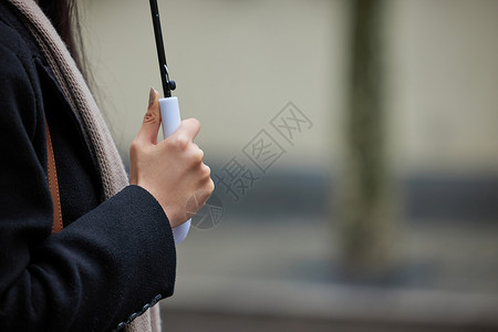 下雨天撑伞的女性手部特写图片