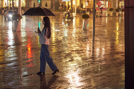 下雨天过马路的都市女性图片