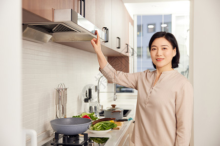居家女性厨房使用吸油烟机形象图片