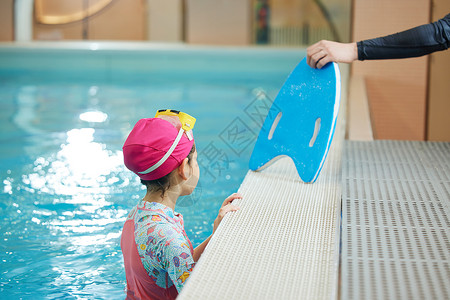 游泳教练给学员递漂浮板图片