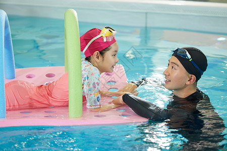 游泳馆指导小女孩游泳的教练游泳课高清图片素材