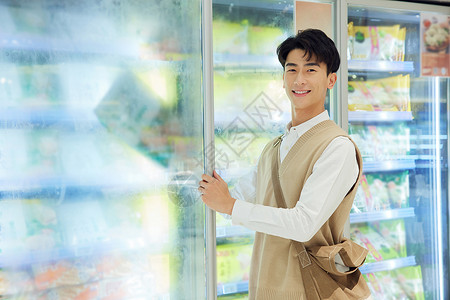 男性在超市冷冻区挑选食材高清图片