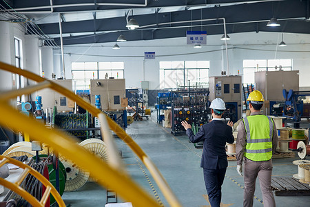 企业安全生产商务老板和工程师巡视工厂车间背影背景