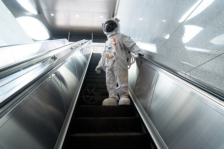 穿宇航员乘坐地铁电梯的男性图片