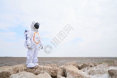 太空岩石海滩边穿着宇航服的男性背景