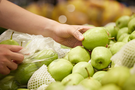 水果促销展板在超市把水果装进塑料袋的动作特写背景