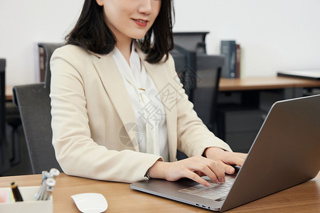 职场商务女性使用笔记本电脑办公特写图片