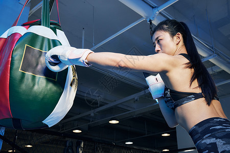 女性拳击运动员准备击打拳击沙袋图片