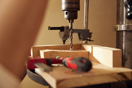 螺杆机男性工匠使用钻木机打孔特写背景