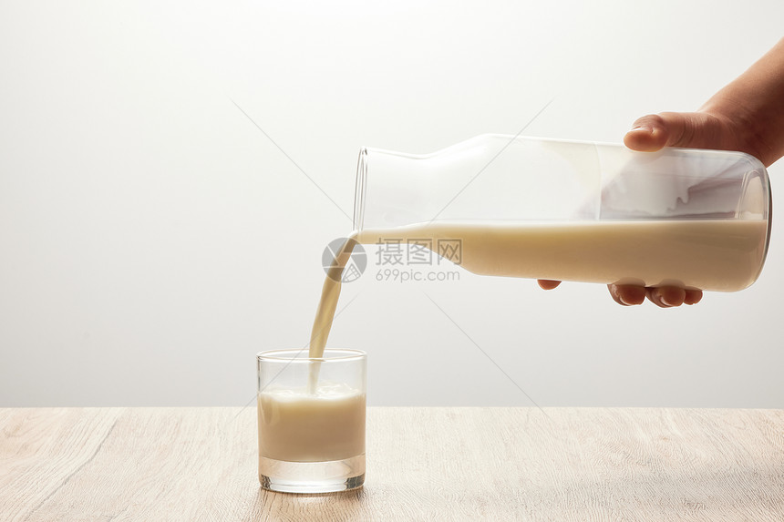 把牛奶从瓶子里倒在玻璃杯中图片