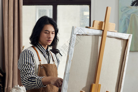 油画工作室里创作的男画家背景图片