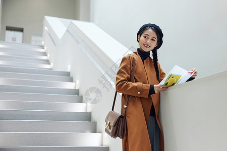 文艺女青年看展览画册介绍背景图片