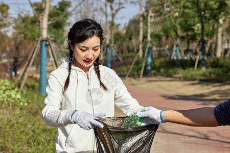 当我清理时女性在室外参加公益活动清理垃圾背景