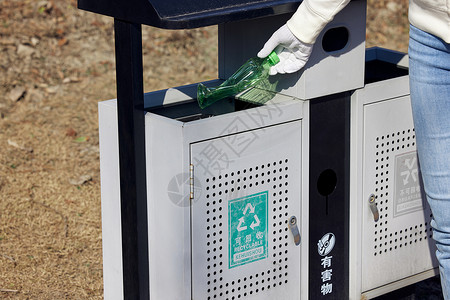 城市低碳生活瓶罐放进可回收物垃圾箱背景