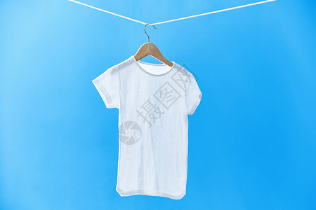 蓝色T恤室外晾衣绳上晾晒着的儿童T恤衫背景