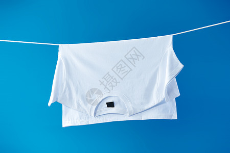 晾晒的衣物晾衣绳上晾晒着的白T体恤衫背景
