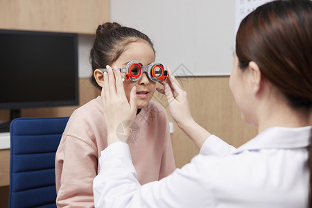 儿童体检视力医生给小女孩配眼镜背景
