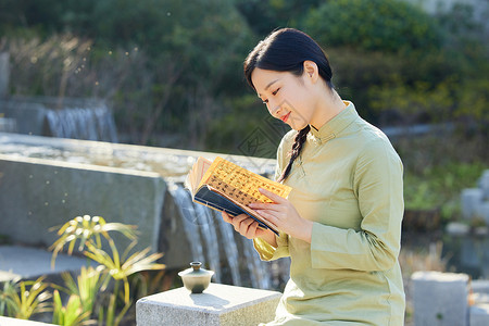户外品茶看书的青年女性背景图片