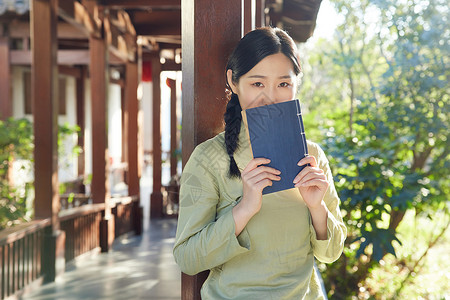 气质女性户外看书背景图片