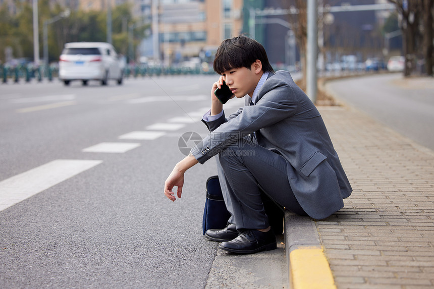 坐在马路边打电话的职场男性图片