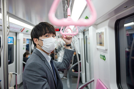 戴口罩乘坐地铁的职场青年图片