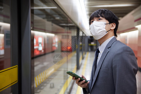 地铁上戴着口罩等待的男性图片