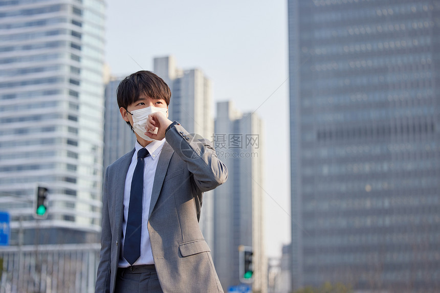 城市里戴着口罩的商务青年咳嗽图片