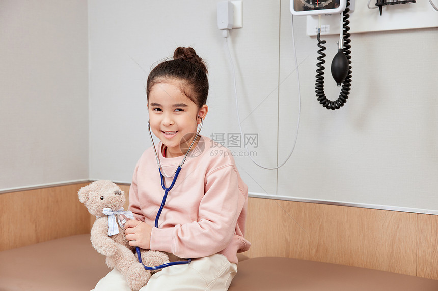 给小熊使用听诊器的小女孩图片