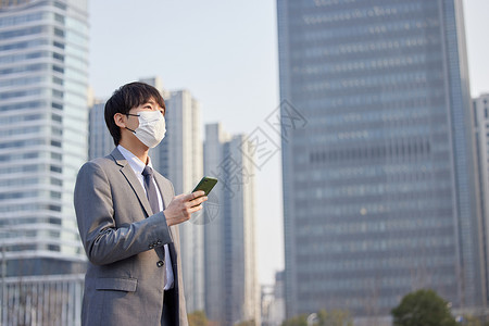 休息徒步戴口罩的商务男性室外拿着手机背景