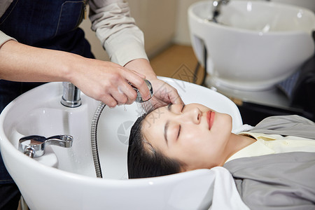 给顾客洗头的理发师女性高清图片素材