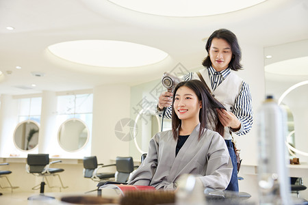 理发师给女性顾客吹头发染发高清图片素材