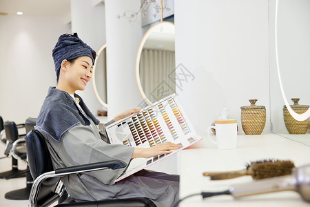 阅读沙龙理发店的女性顾客挑选染发发色背景