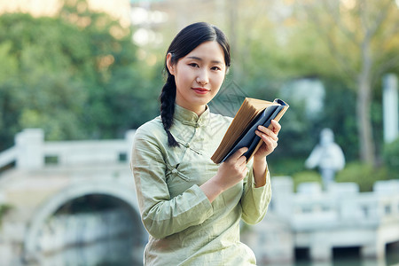 气质女性户外赏植看书背景图片