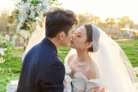 举行户外婚礼的新郎新娘甜蜜接吻背景图片