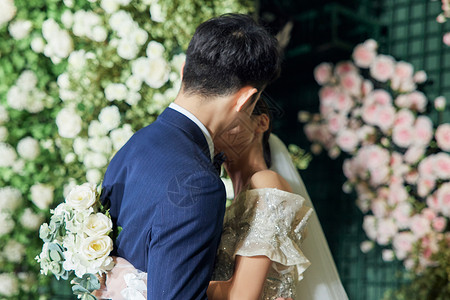 婚礼上甜蜜拥吻的新郎新娘背景图片