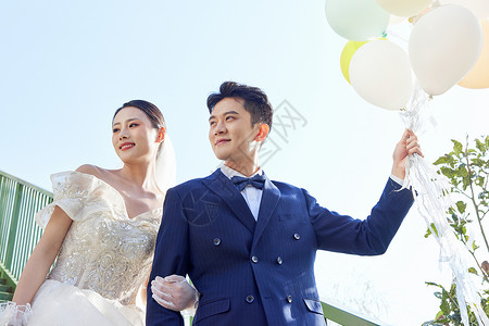婚礼氛围手拿气球的新婚夫妻背景