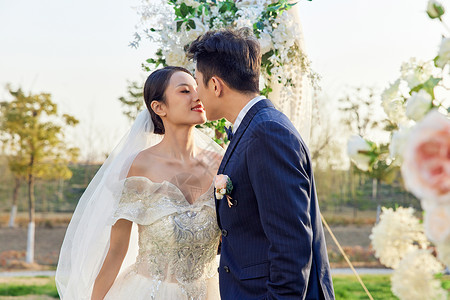 举行户外婚礼的新郎新娘甜蜜拥吻背景图片