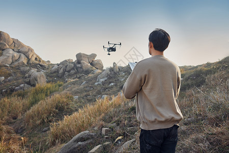 户外登山运动航拍摄影师使用无人机拍摄背影背景
