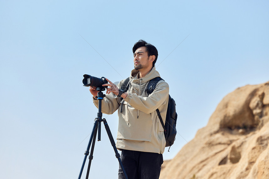 户外登山使用三脚架拍摄的摄影师图片