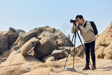 户外登山的摄影师户外登使用三脚架拍摄山景背景图片