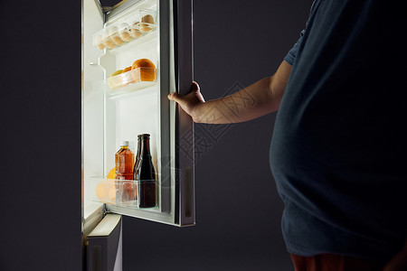 肥胖男士半夜开冰箱觅食特写高清图片