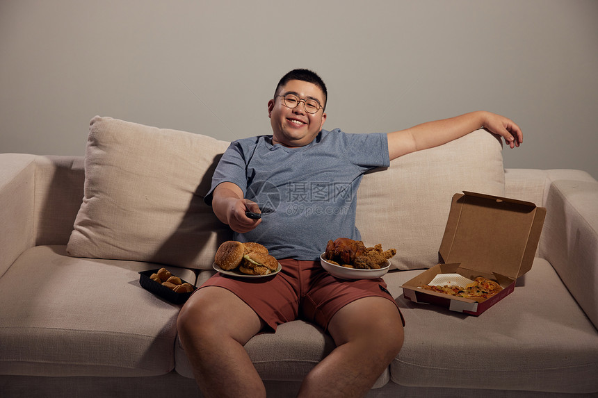 居家肥胖男青年熬夜看电视吃夜宵图片