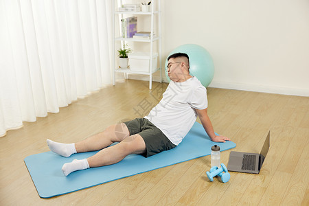 肥胖男青年瑜伽垫上锻炼疲惫图片