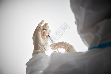 医生穿手术服穿防护服的医护人员手拿疫苗特写背景