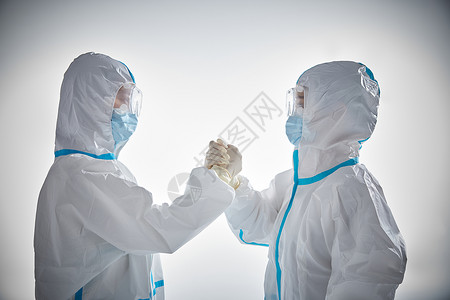 新冠疫情穿防护服的医护人员握手打气形象背景