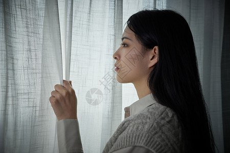 独居在家的女孩看向窗外忧郁高清图片素材