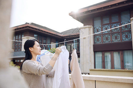 室外阳台晾晒衣服的女性形象高清图片