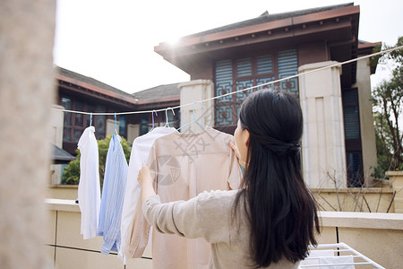 阳台晾晒晾晒衣服的女性形象背景