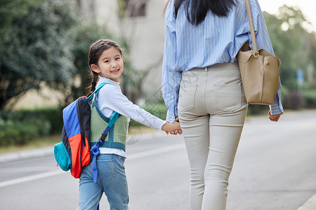 牵着妈妈的孩子妈妈牵着女儿上学背景