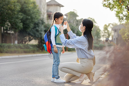 妈妈给上学的女儿戴口罩高清图片